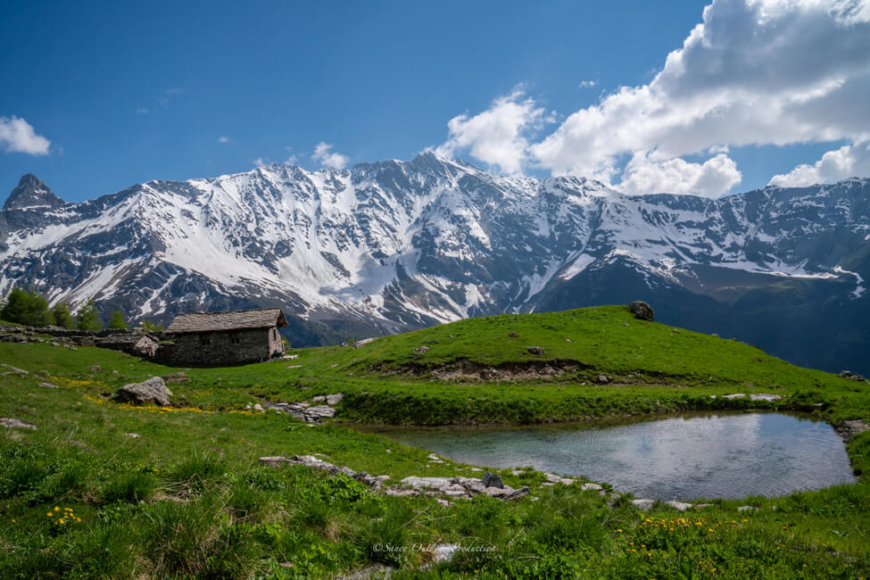 Paysage alpin avec une maison au second plan et des montagnes