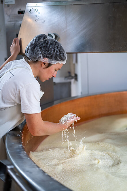 Homme s'occupant de remuer un contenant rempli de fromage